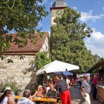 Feiern vor historischen Mauern: Straßenweinfest in der Kirchenburg in Hüttenheim.
