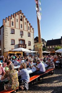 Beim Weinfest sitzen Einheimische und Besucher gesellig beisammen.