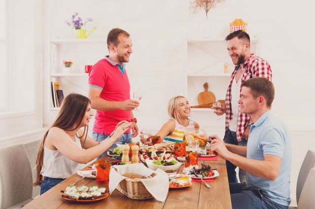 Group of happy people at festive table dinner party Skandinavische Behaglichkeit zelebrieren und sich mit besonderen kulinarischen Ideen verwöhnen: