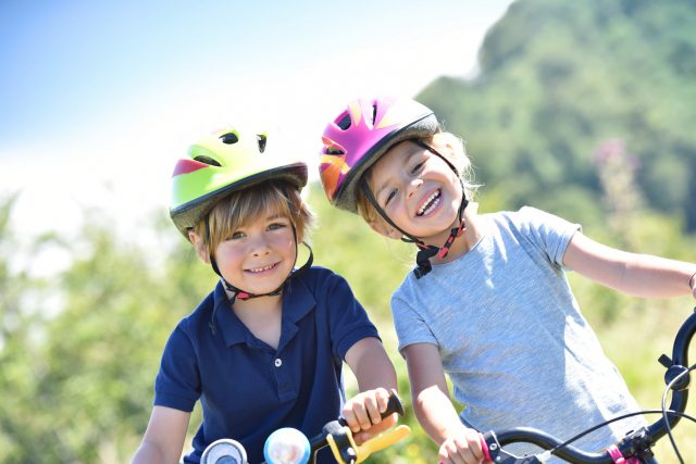 Portrait of cheerful kids riding bikes Kinder beim Fahrradfahren