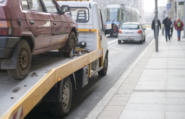 Roadside assistance car towing truck in the city Nicht immer übernimmt der Automobilclub die Abschleppkosten.