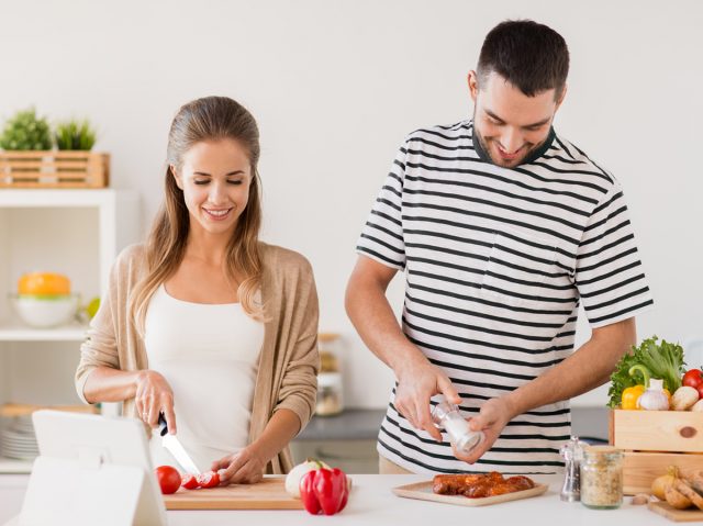 happy couple cooking food at home kitchen
