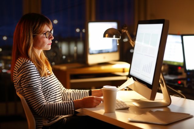 Frau arbeitet im Büro bis in die Nacht hinein - Schichtarbeiter