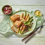 Geflügel und Spargel sind nicht nur lecker, sondern auch ein leichtes, fettarmes und zudem gut verträgliches kulinarisches Duo, wie hier bei dem Rezept "Putenfilet mit zweierlei Spargel im Speckmantel und Radicchio-Salat". Foto: djd/Deutsches-Geflügel.de