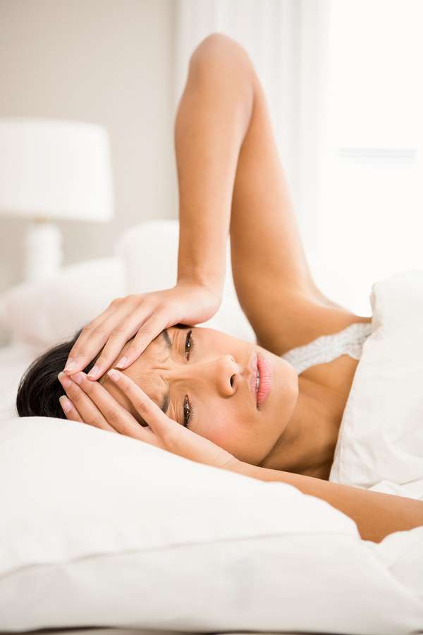Migräneanfälle senken: Viele Migränepatientinnen wachen morgens schon mit den bohrenden Kopfschmerzen auf.