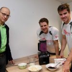 Immunsystem im Powermodus:Richard Schmidt (m.) und Torben Johannesen (r.) vom Team Deutschland-Achter mixen zusammen mit dem Ernährungsexperten Uwe Schröder vom Deutschen Institut für Sporternährung immunstärkende Frucht-Shakes. Foto: djd/Dr. Wolz Zell