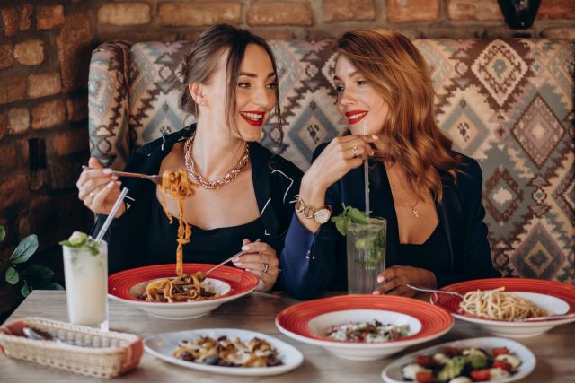 Two women eating pasta in an italian restaurant Gutscheinbuch.de Würzburg