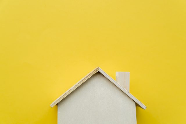 close-up-of-wooden-miniature-house-model-on-yellow-background Minimalismus leben für dummies