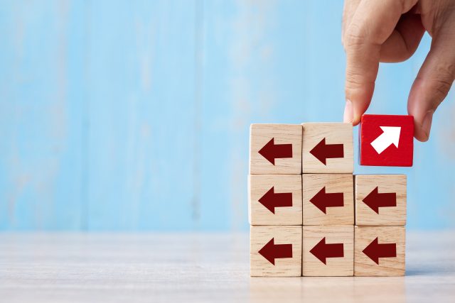 Businessman hand placing or pulling Red block with different dir Zukünfte - Offen für Vielfalft