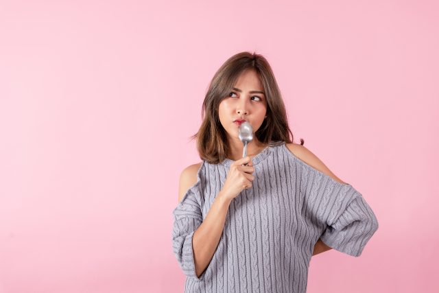 Portrait of an Asian woman holding a spoon in his hand Denk dich schlank