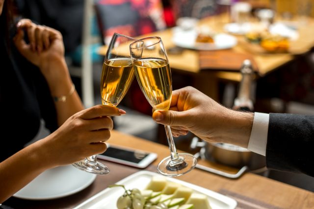 mans are holding the glasses with champagne with fruit plate side view Schlemmerblock Bad Kissingen