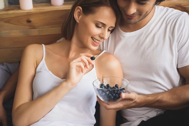 close up of a pair eating blueberries