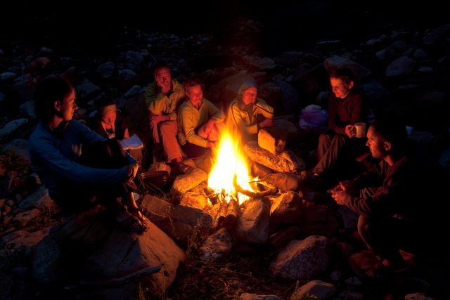 People near campfire in forest.