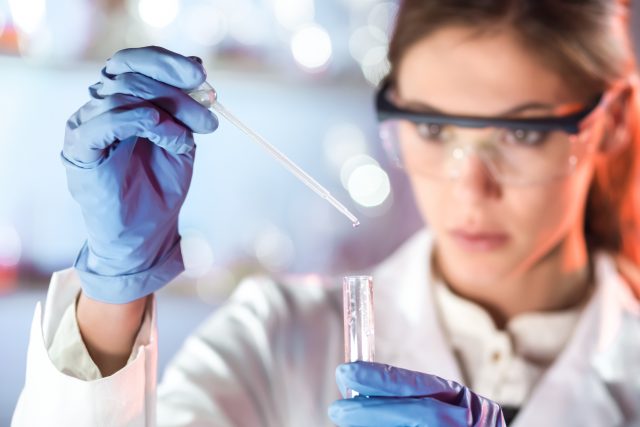 Young scientist pipetting in life science laboratory.