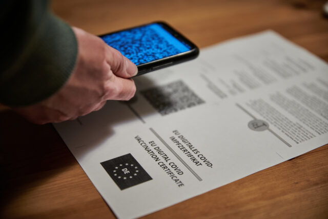Person scanning the QR code of a covid 19 certificate. Scanning the coronavirus green pass.