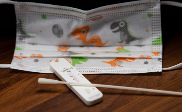 Negative result of the covid-19 antigen test in front of a Covid face mask for children