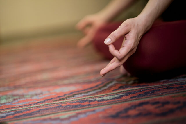 Detail of hands while meditation. woman practicing yoga concept natural balance between body and mental development.