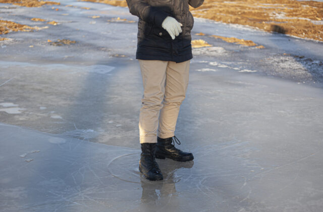 Army boots in the winter. A girl is standing on the ice.